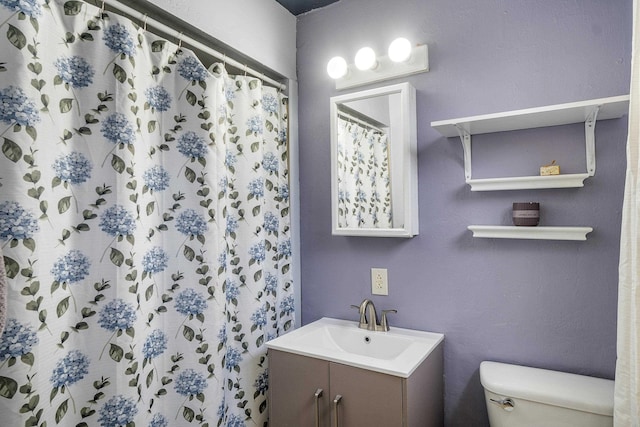 bathroom featuring a shower with curtain, vanity, and toilet