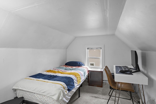 carpeted bedroom featuring a baseboard heating unit and vaulted ceiling