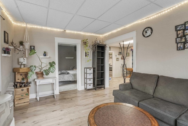 living room featuring a paneled ceiling and wood-type flooring