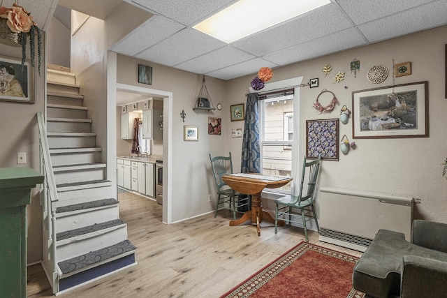 interior space with a paneled ceiling, light hardwood / wood-style floors, and sink