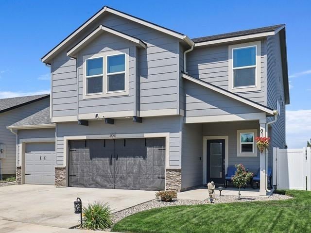 craftsman-style house featuring a garage and a front yard