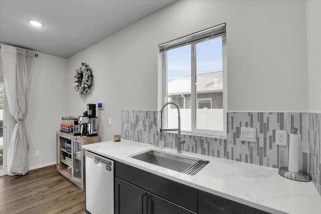 kitchen with dark hardwood / wood-style flooring, tasteful backsplash, light stone counters, sink, and dishwasher