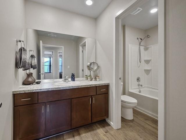 full bathroom with shower / washtub combination, vanity, wood-type flooring, and toilet