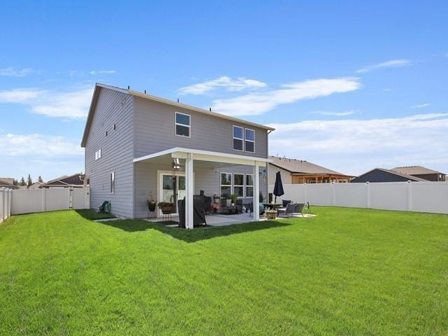 rear view of property featuring a yard and a patio