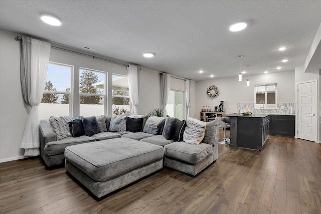 living room with dark wood-type flooring and a textured ceiling