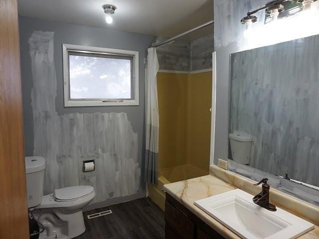 bathroom with hardwood / wood-style flooring, a shower with curtain, toilet, and vanity