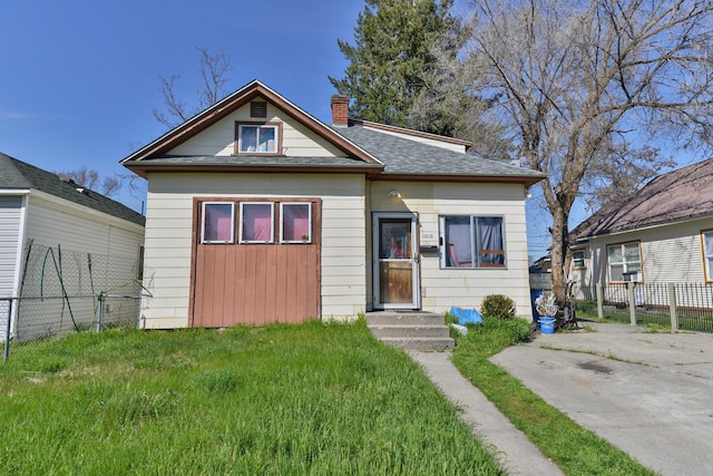 bungalow-style home with a front lawn