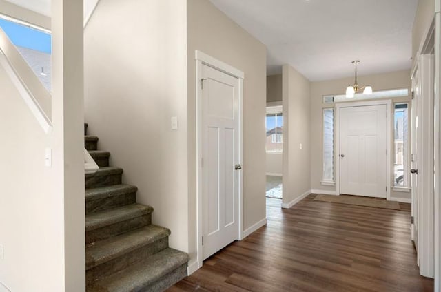 entrance foyer with dark hardwood / wood-style flooring and an inviting chandelier