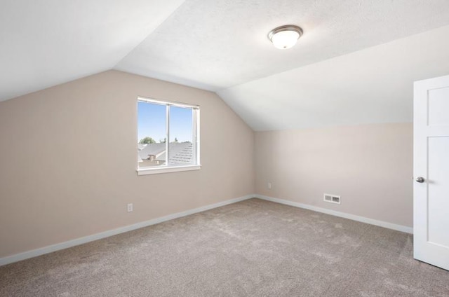 bonus room featuring light colored carpet and lofted ceiling