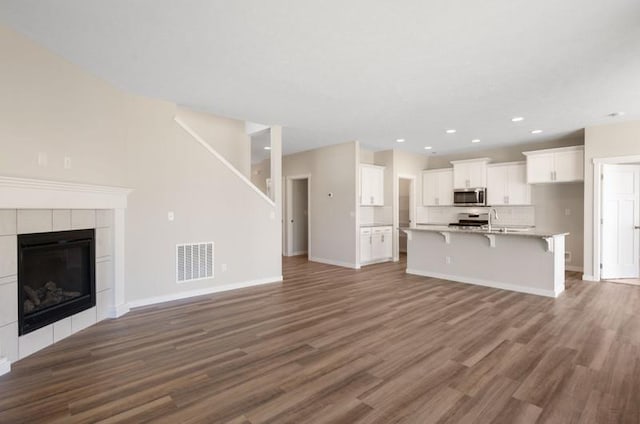 unfurnished living room with a fireplace, dark hardwood / wood-style floors, and sink