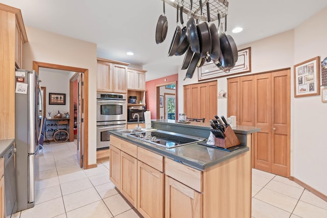 kitchen featuring light tile patterned flooring, light brown cabinets, an island with sink, and stainless steel appliances