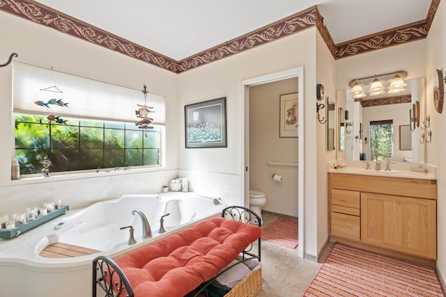 bathroom featuring tiled tub, tile patterned flooring, vanity, and toilet