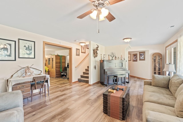 living room featuring ceiling fan and light hardwood / wood-style flooring