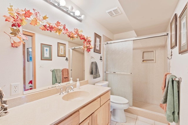 bathroom featuring tile patterned flooring, vanity, toilet, and a shower with door