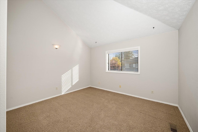 carpeted empty room with a textured ceiling and vaulted ceiling