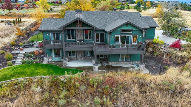 rear view of house with a patio area, a yard, and a wooden deck