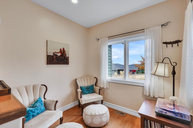 living area with hardwood / wood-style flooring and a healthy amount of sunlight