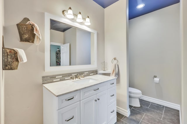 bathroom featuring decorative backsplash, vanity, tile patterned flooring, and toilet