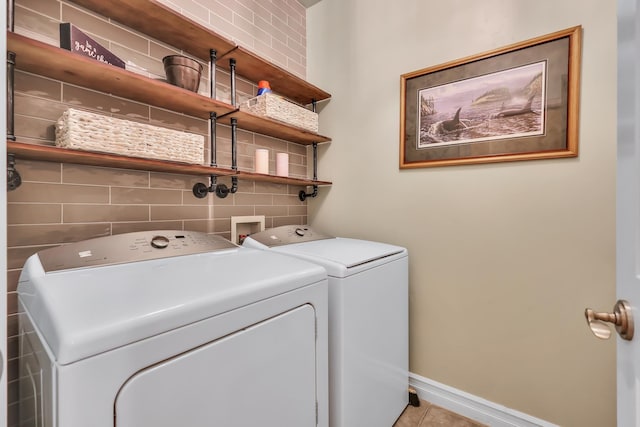 clothes washing area with light tile patterned floors and washing machine and dryer