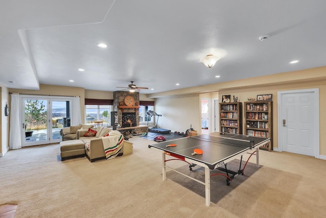 playroom featuring a fireplace, light colored carpet, and ceiling fan