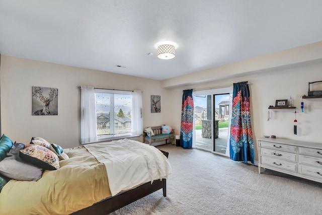 bedroom featuring access to outside, multiple windows, and light colored carpet