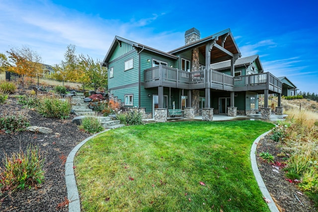 back of property featuring a deck and a yard