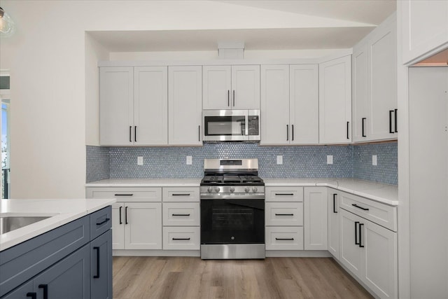 4217 W Tolliver Ct, Spokane, WA 99208 - kitchen featuring appliances with stainless steel finishes, light wood-style floors, tasteful backsplash, and light stone countertops