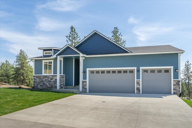 4217 W Tolliver Ct, Spokane, WA 99208 - craftsman inspired home with stone siding, an attached garage, driveway, and a front yard