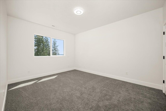 4217 W Tolliver Ct, Spokane, WA 99208 - empty room featuring dark carpet and baseboards