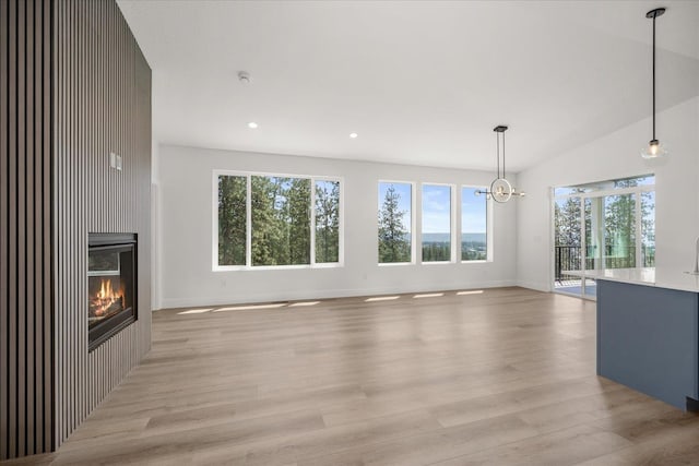 4217 W Tolliver Ct, Spokane, WA 99208 - unfurnished living room with light wood-style flooring, recessed lighting, a glass covered fireplace, and a chandelier