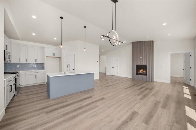 4217 W Tolliver Ct, Spokane, WA 99208 - kitchen with appliances with stainless steel finishes, vaulted ceiling, a chandelier, tasteful backsplash, and pendant lighting