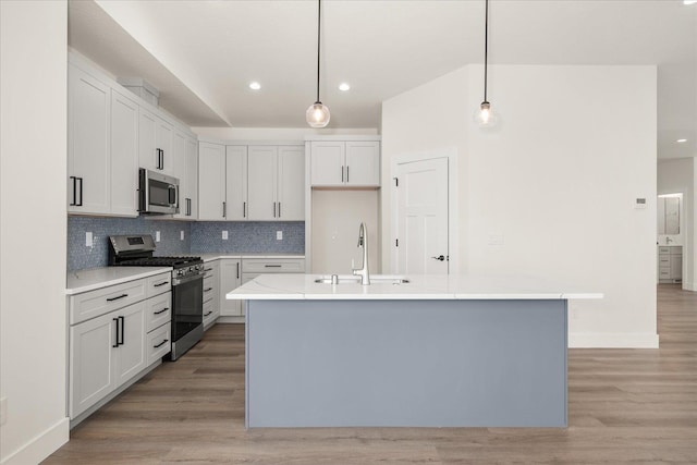 4217 W Tolliver Ct, Spokane, WA 99208 - kitchen featuring stainless steel appliances, decorative backsplash, light wood-style flooring, recessed lighting, and an island with sink