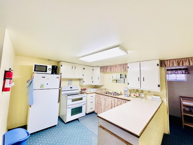 kitchen featuring white cabinetry, sink, white appliances, and kitchen peninsula