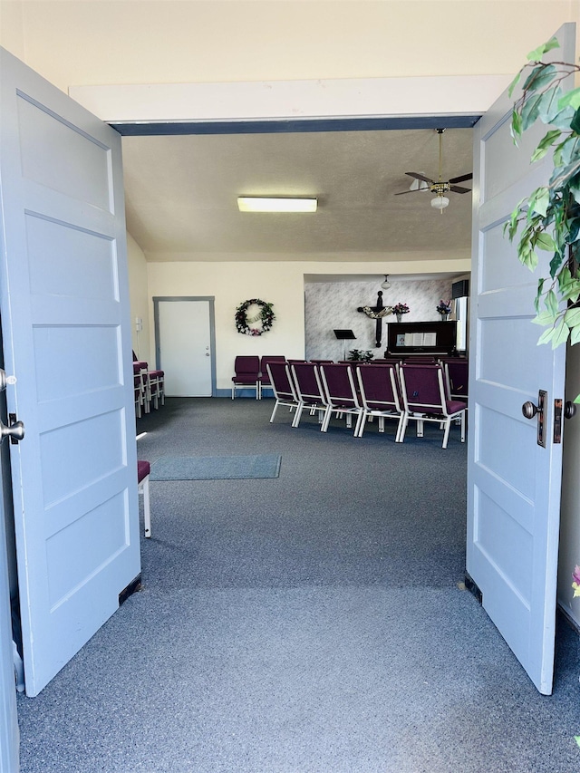 interior space with carpet floors and ceiling fan