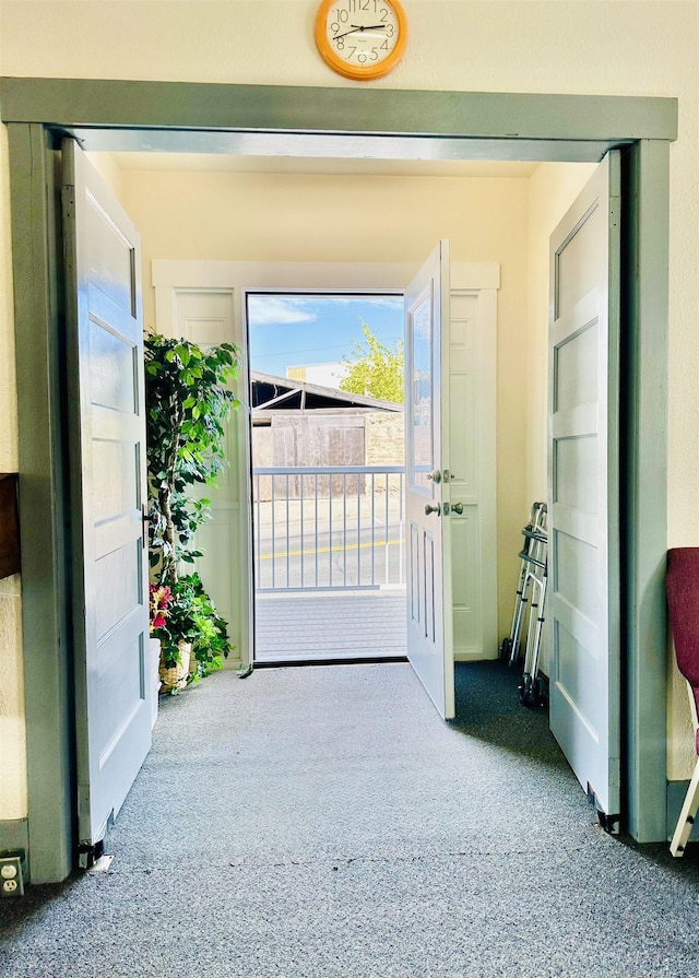 doorway to outside featuring carpet flooring