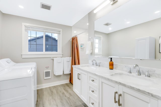 bathroom with hardwood / wood-style flooring, vanity, and separate washer and dryer