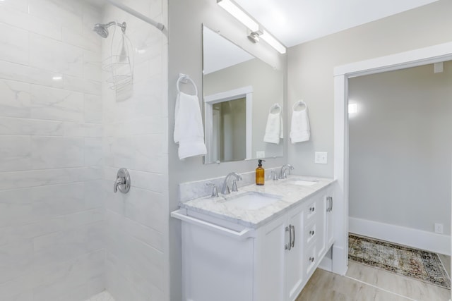 bathroom with a tile shower and vanity