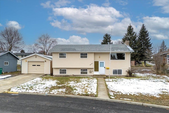 split foyer home featuring a garage and an outbuilding