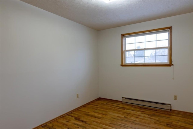 unfurnished room with light hardwood / wood-style floors, a textured ceiling, and a baseboard heating unit