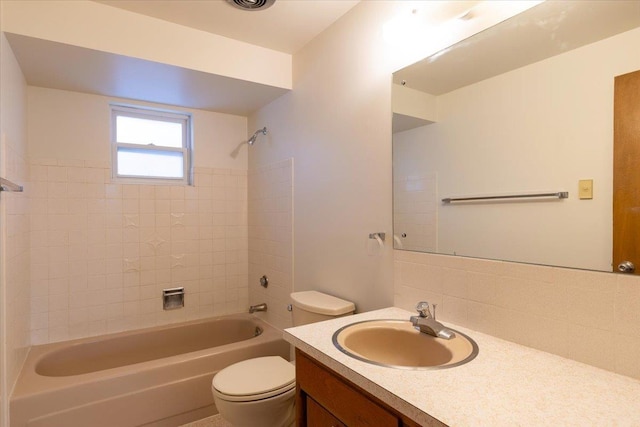 full bathroom with vanity, tiled shower / bath combo, tasteful backsplash, and toilet