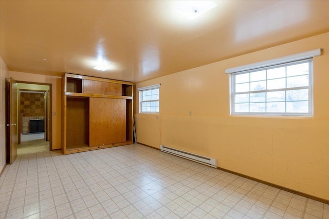 unfurnished bedroom featuring a fireplace, a closet, and a baseboard heating unit