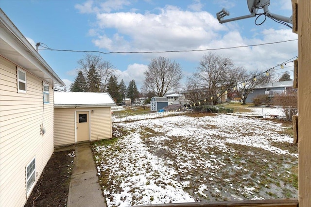 snowy yard featuring an outdoor structure