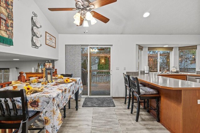 dining space with light hardwood / wood-style floors, ceiling fan, and sink