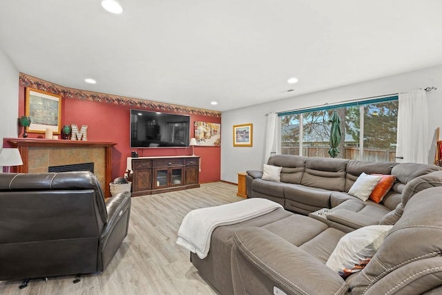 living room with a fireplace and light wood-type flooring