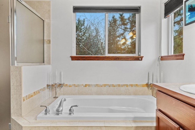 bathroom featuring vanity and a relaxing tiled tub