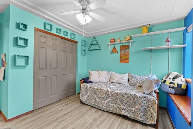 bedroom with hardwood / wood-style flooring, ceiling fan, and a closet