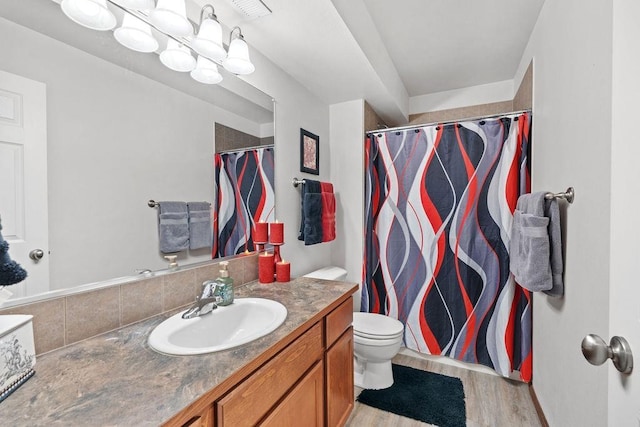 bathroom featuring vanity, toilet, wood-type flooring, and walk in shower