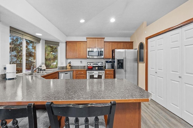 kitchen with a kitchen bar, sink, kitchen peninsula, and stainless steel appliances