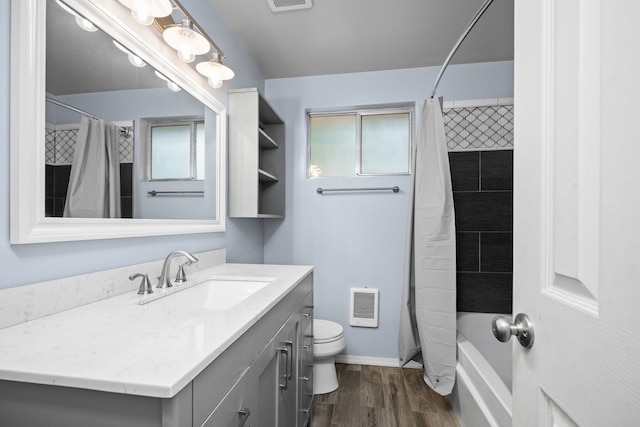 full bathroom featuring hardwood / wood-style floors, vanity, shower / bath combo, and toilet