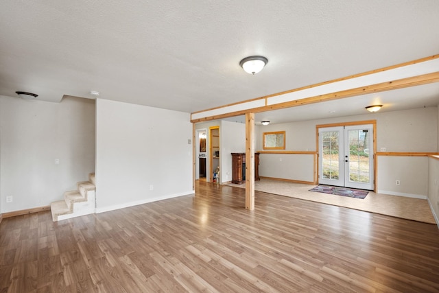 interior space featuring french doors, a textured ceiling, and light hardwood / wood-style flooring